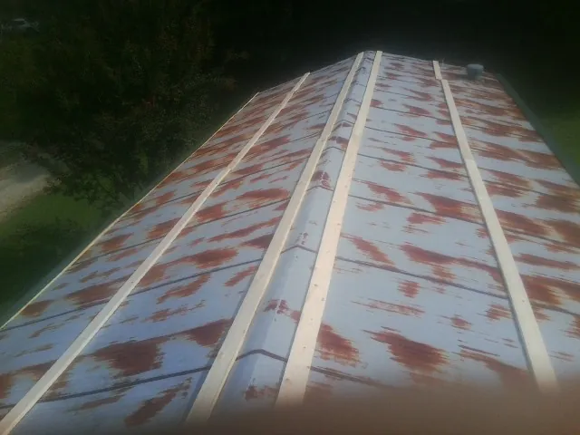 Rusted metal roof panels with new wood purlins before replacement — Storm Damage Roof Repair in Saint Marys by Roofing Brothers